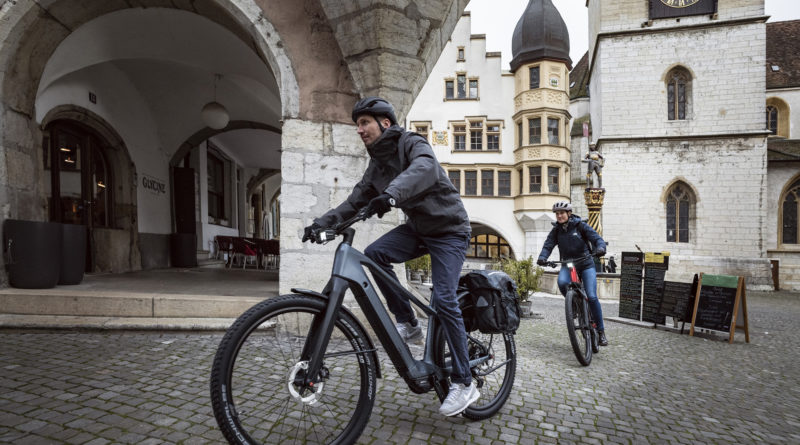 Urban e-bike cyclists riding on cobbled streets