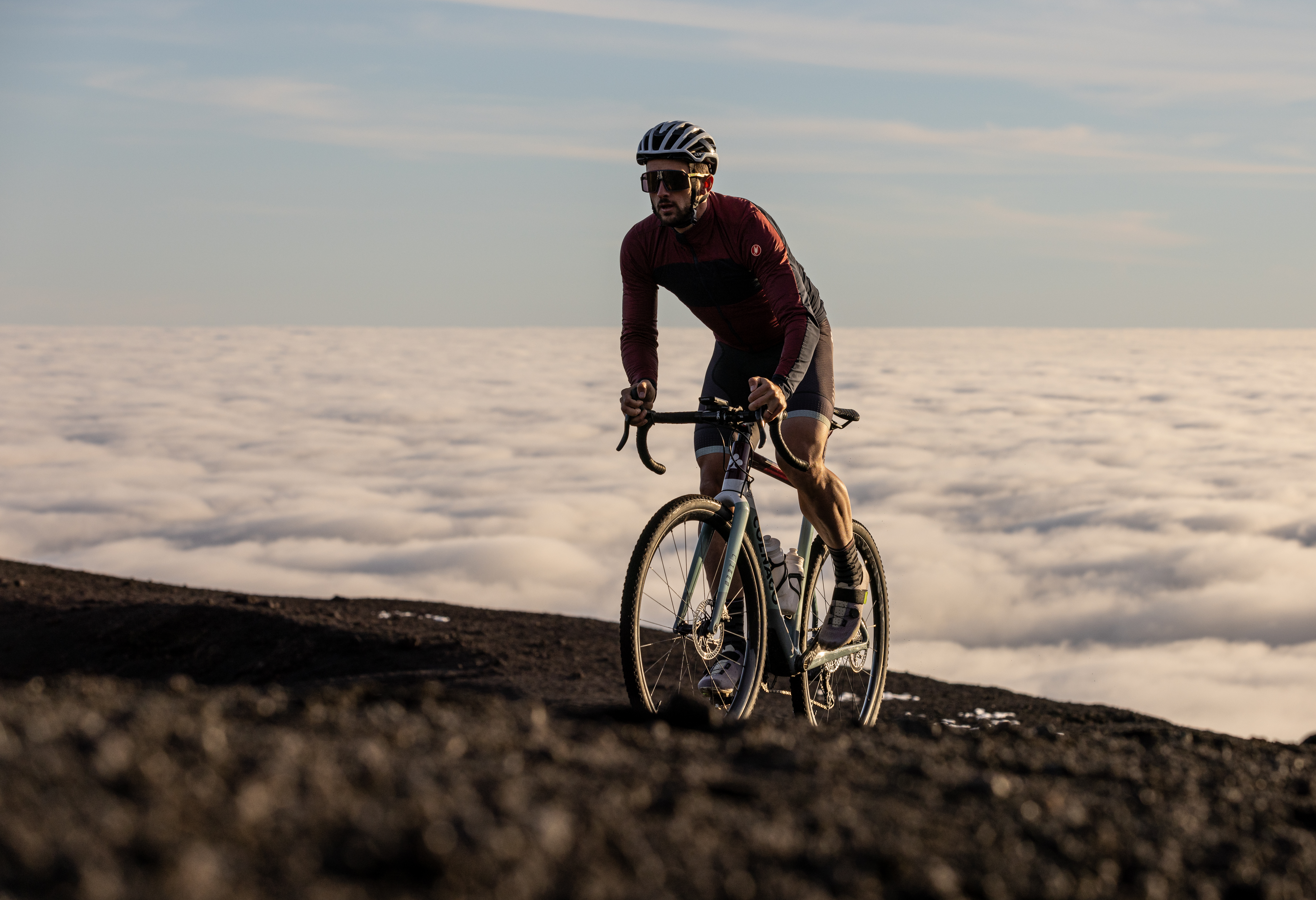 Campagnolo Levante gravel wheels on a bike being ridden on gravel, with a cloud inversion in the background