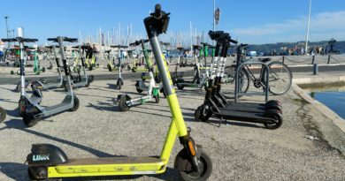 e-scooters parked in a socail space with water in the background