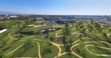 Drone view architects impression of Vittoria park; bike tracks gravel amongst grass and trees with buildings in background on skyline