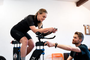 Women on TT bike having conversation with bike fitter adjusting the height of the front of the bike