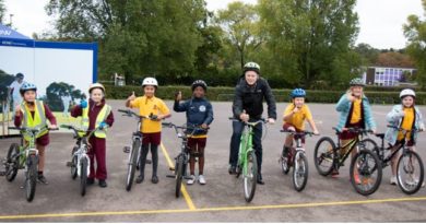 Children on bikes lined up with Grant Schapps, Transport Minister, amongst them