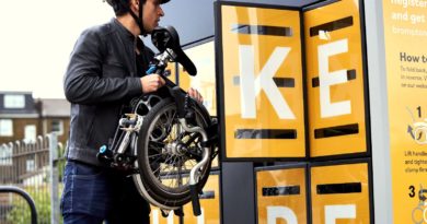 Man lifting folded Brompton out of a Brompton Bike Hire station