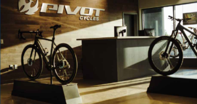 Pivot Cycles showroom - brand logo on far wall, two bikes on plinths, sunlight streaming on frmo the right side of the shot