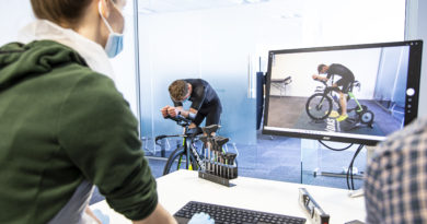 Bianca reviewing footage of a bike fit on screen whilst the rider is on the bike to her left