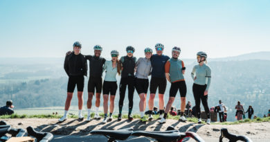 Moloko Cycling on tour - riders stood with stunning blue skies and countryside hills behind them