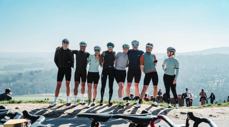 Moloko Cycling on tour - riders stood with stunning blue skies and countryside hills behind them