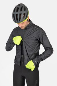 Man in full winter ride kit, using 2-way zip to open jacket from bottom up