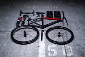 Custom build bike laid out like an exploded diagram on a concrete carpark floor with white road markings