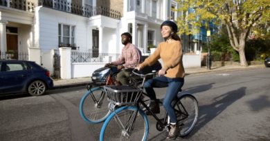Woman and man riding bikes in London, dressed in regular clothing