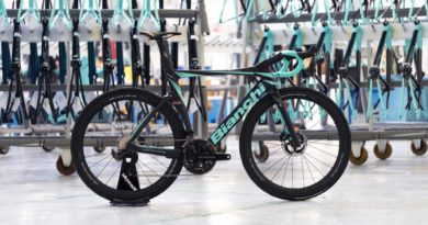 Bianchi X Team Arkéa-Samsic bike in foreground with framesets slightly out of focus hung on wall in background