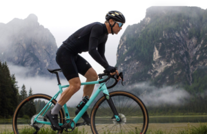 Nico Roche riding a gravel bike with mountains  and low cloud in the background