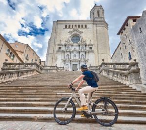 Cyclist at foot of steps to cathedral in Girona Old Town