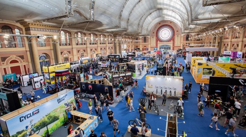 Overhead view of the exhibition hall with people walking the isles between cycling brands stands