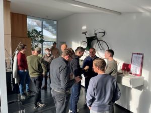 Porsche eBike team stood chatting in meeting space with bike hung on wall