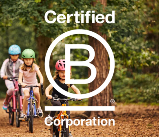 Children riding bikes on woodland walkway with B Corp logo overlay on image