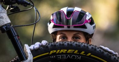 Jolande Neff peaking over the top of a Pirelli shod mountain bike front wheel