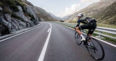 Man riding on European road with rocky mountains on either side