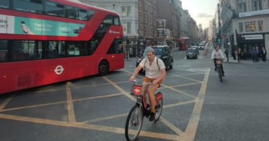 TFL sponsored bikes being ridden in London, alongside red bus and London cab