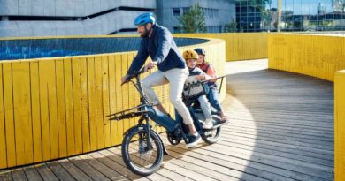 Man riding carg eBike with 2 children onboard