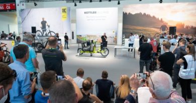 Crowd stood around watching and listening as cargo bike is presented at IAA Mobility