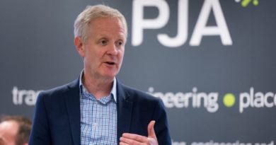 Phil Jones speaking infront of a PJA branded backwall