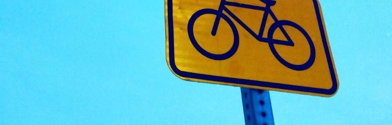 Bicycle sign with blue sky behind it