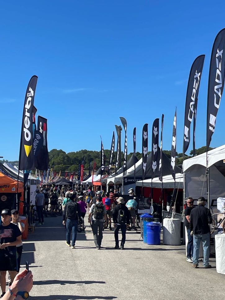walking the Sea Otter Classic expo area with gazebos and flags forming a street