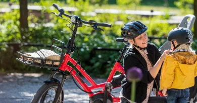 Woman and child beside Tern eBike as child has helmet fitted