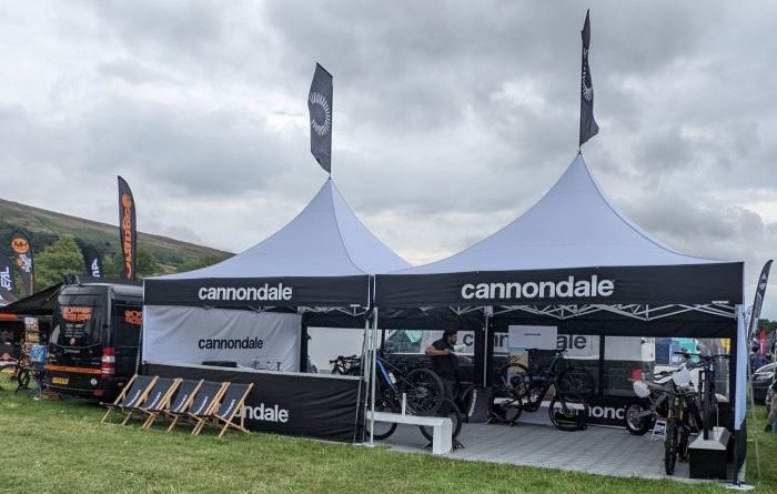 Cannondale marquees with bikes in and seats outside, in a green field setting