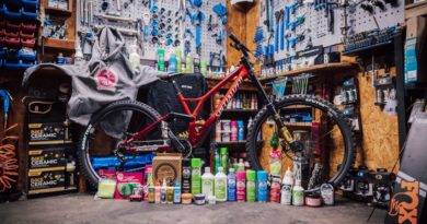 Juice Lubes range laid out in front of a mountain bike in a workshop setting