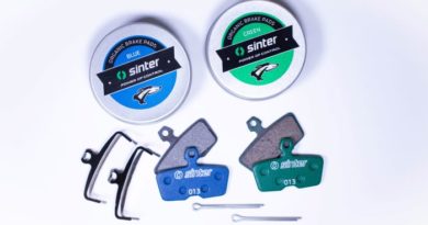 Sinter Blue and Green pads laid out with branded tins each set of pads comes in
