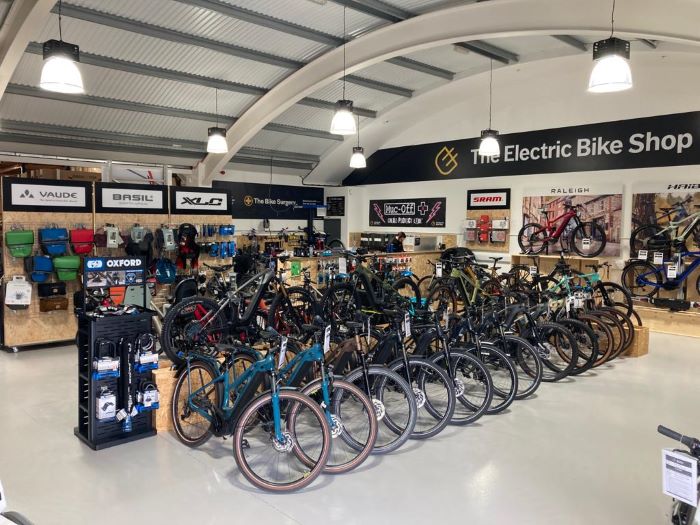 Inside of one of The Electric Bike Shop stores, with bikes on display and branding on the walls