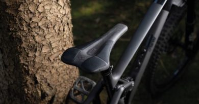 SQlab 611 Infinergy Ergowave active 2.1 Carbon saddle fitted to bike lent against tree. Close up shot.