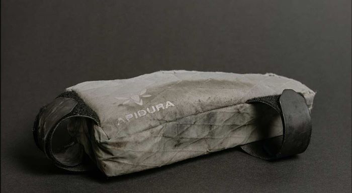 Emily Chappell’s Apidura Top Tube Pack lay on its side, clearly showing 2 years of hard, good, use. Pictured in close up grey scale image. 