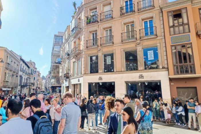 Eat Sleep Cycle Malaga hub, with crowd gathering the street outside the location