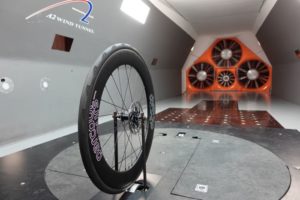 Wheel mounted on wind tunnel with fans at far end of field of vision
