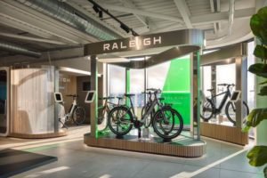 Raleigh branded display unit with eBike on stand, inside Norwich Electric Forecourt