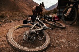 SRAM GGX Eagle Transmission equipped bike lay on the dirt with a horse near by. 