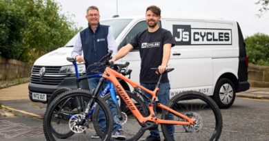 Andy Clough of Mercia, left, with James Wagner of J’s Cycle Shack. Andy holding Pinarello road bike, James holding Specialized eMTB. J's Cycles branded van behind them.