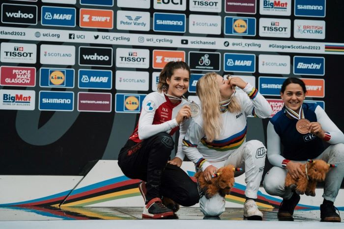 UCI Women’s Elite Downhill podium with athletes showing off medals