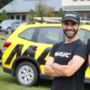 Josh Saxe, Mavic North America Manager of Sales and Marketing, stood in front of a Mavic branded yellow car