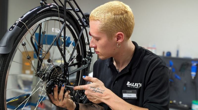 Luke Simpson at Balfe's Bikes on a Cytech apprenticeship, working on bike in workshop work stand
