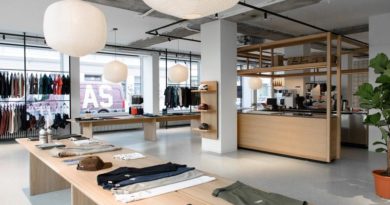 Pas Normal Studios Munich wide shot inside the store showing product laid out on benches as well as hung on rails