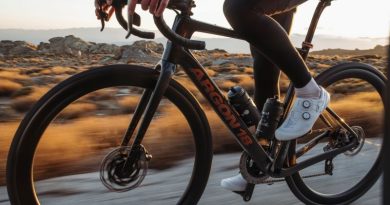 Close up shot of Argon 18 road bike ridden in warm sunlight on road with orange scrub in the background