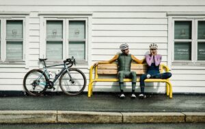 Gobik wearing woman and man sat with bike to one side